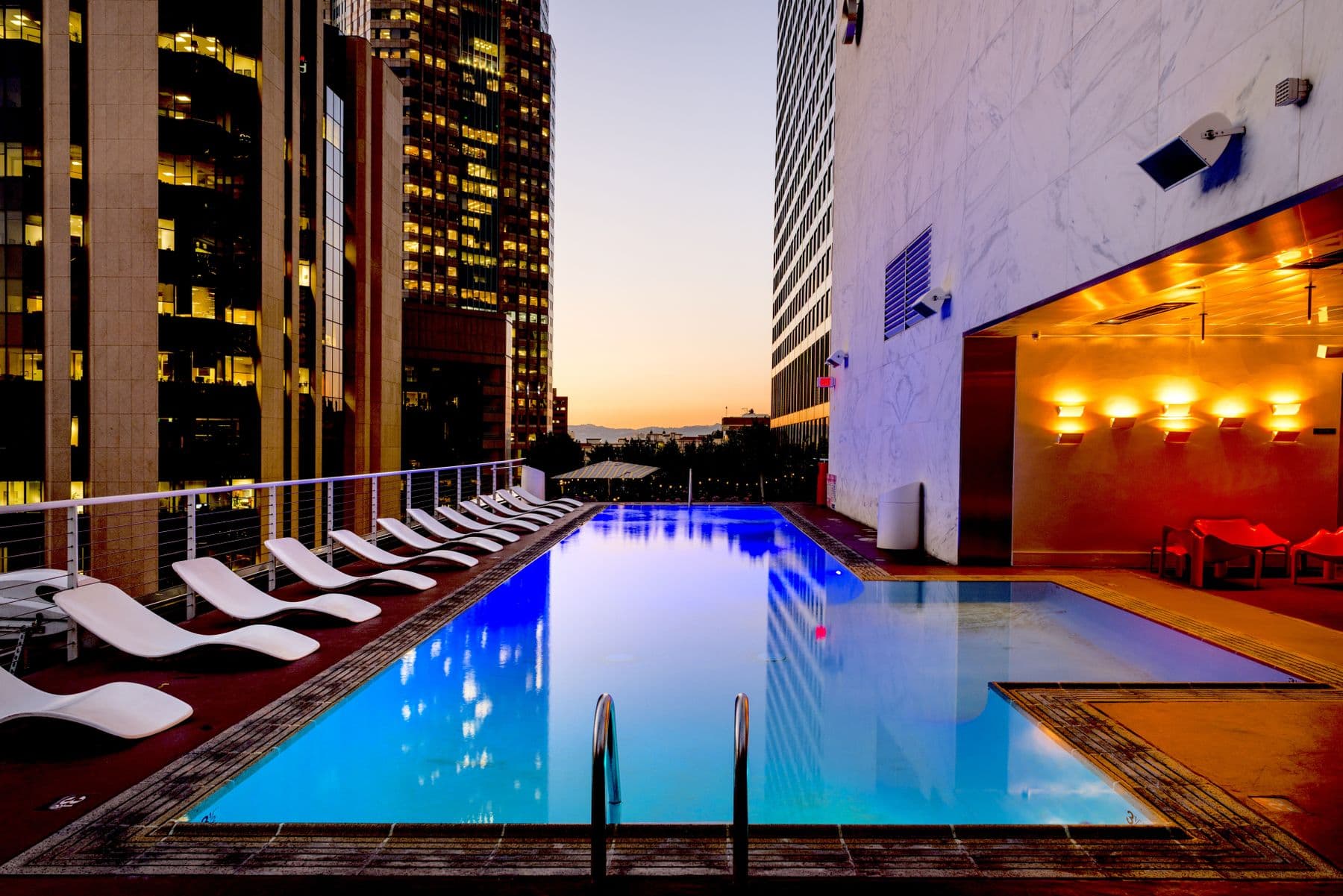 Resort pool at sunset with lounge seating